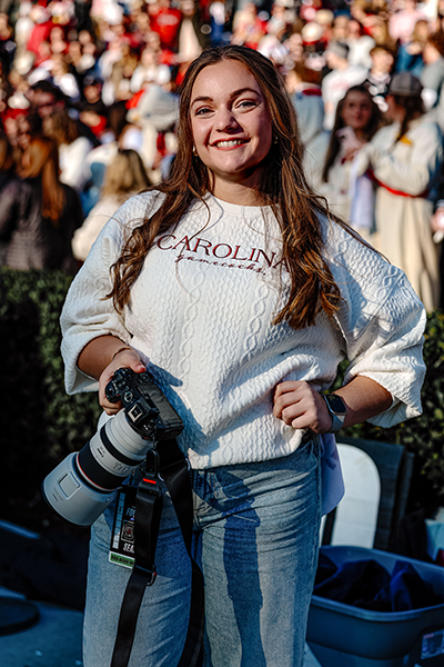 Alicia Caracciolo holding a camera at a football game