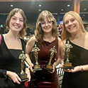 three ladies holding ADDY trophies