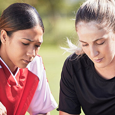 pair of young women in sports uniforms