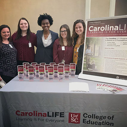 smiling women with CarolinaLIFE pamplets and sign