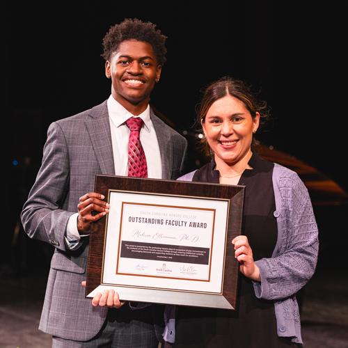 Melissa Ellermann holding her award with Zachary Brown
