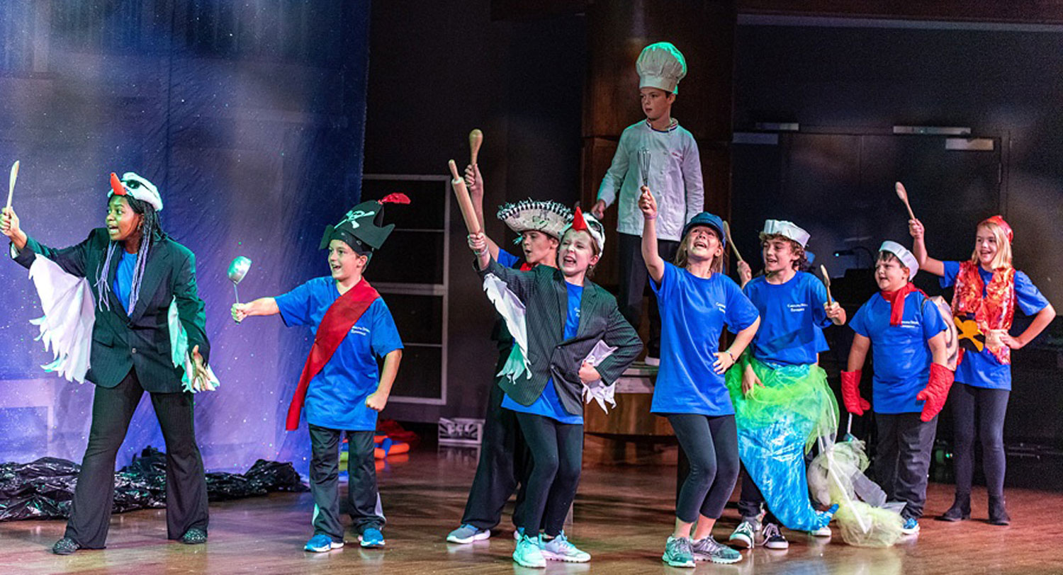 Children in costume on stage for theater camp