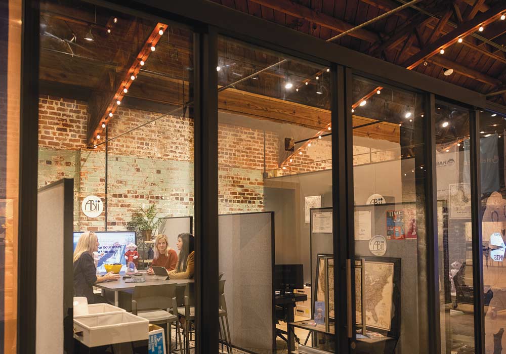 The back of the Five Points property that houses GrowCo. and you’ll see a brightly lit coworking space under a barrel vault ceiling. Van Robotics, a personalized learning tool company launched by CEO Laura Boccanfuso, occupies the first glass cube on your left.